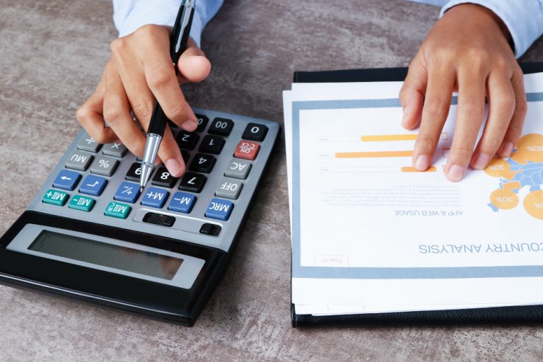 Pessoa utilizando calculadora e analisando relatório financeiro durante planejamento e controle de despesas.