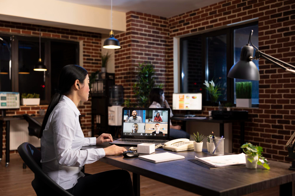 Profissional trabalhando em casa e participando de uma videoconferência pelo notebook, representando o trabalho remoto com sede virtual.